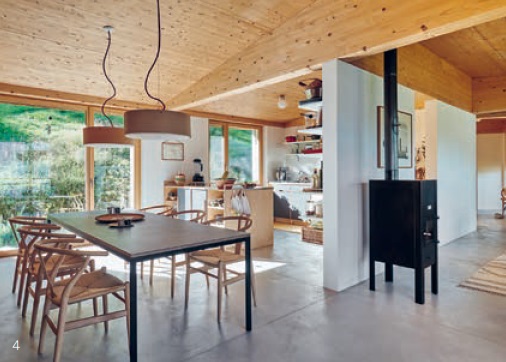 The dining area connects the kitchen with the living room and the terrace. Large windows open up the view of nature.