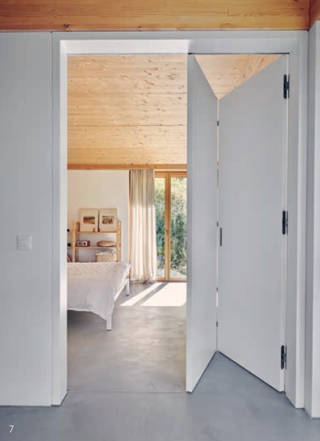Eine weisse Falttür dient als Raumtrenner zwischen Schlafzimmer und Flur, ohne jedoch die offene Atmosphäre zu unterbrechen.
