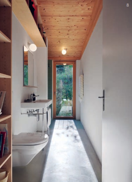 Das schlicht gestaltete Bad mit Toilette, Dusche und Lavabo führt direkt in den Aussenbereich hinter dem Haus.