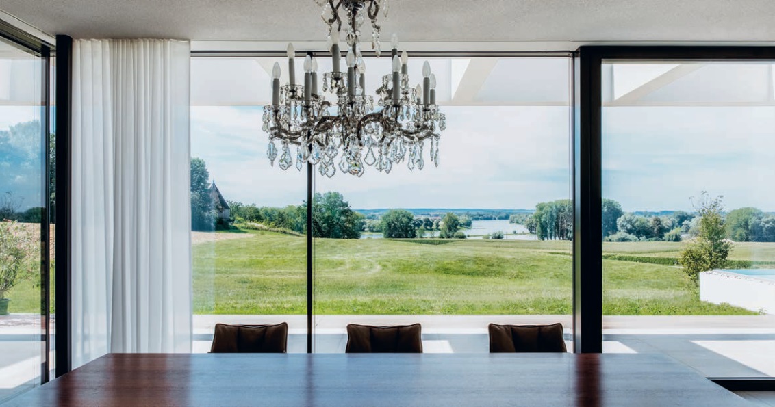 Der Kronleuchter ist ein verspielter Blickfang und steht im Kontrast zum zurückhaltenden Interieur der Villa.