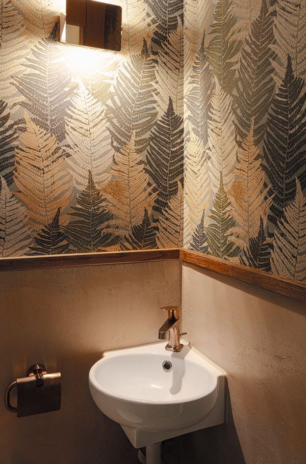 Im WC wurde das Waldthema mit der auf den Zentimeter eingepassten Wandtapete «Everyday moments: Fern forest» und dem darunter angebrachten, farblich abgestimmten Spachtelbelag aufgenommen.