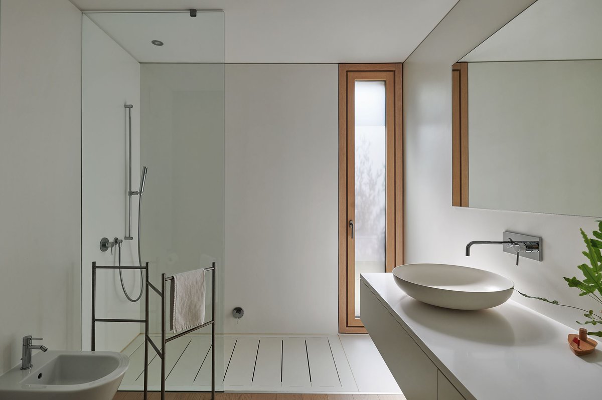 Im Bad – gleichzeitig Garderobe – dominiert der Einbauschrank, der zur Ablage mit Waschbecken wird. Eine mattierte Milchglasschiebetüre trennt bei Bedarf die Funktionsräume.