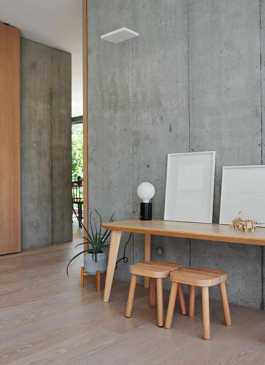Der im ganzen Innenraum des Hauses ausgelegte Holzboden bildet mit seiner warmen Oberfläche und akustikdämmenden Eigenschaft einen angenehmen Dialog mit dem Sichtbeton.